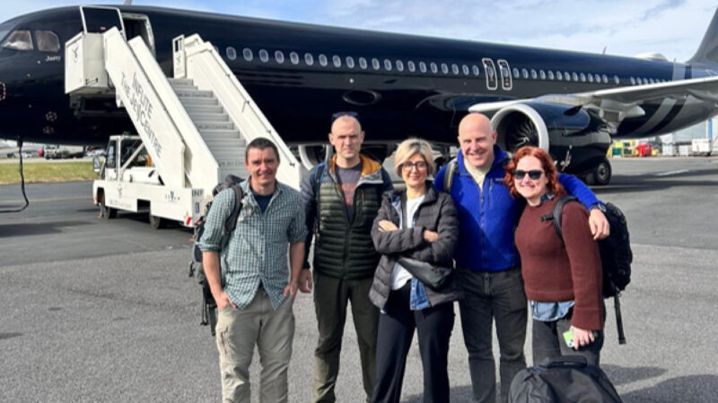 Tom Fletcher and UKHSA team in front of airplane preparing to fly to Ascension Islands to repatriate British citizens.